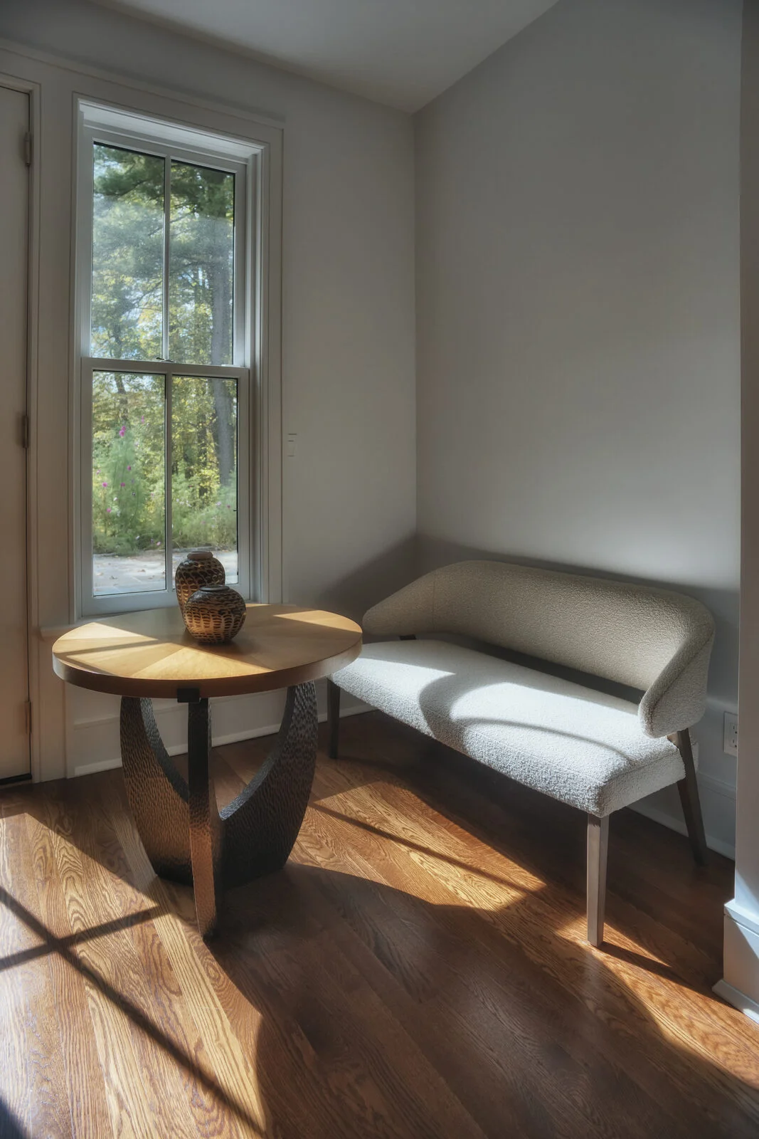 Entry vestibule with curved settee and sculptural side table