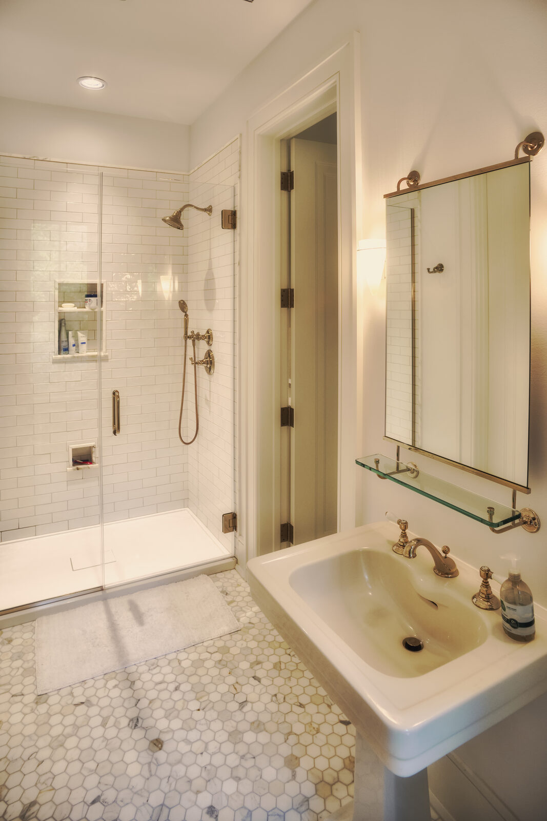 Guest bathroom with brass fixtures and marble hex tile
