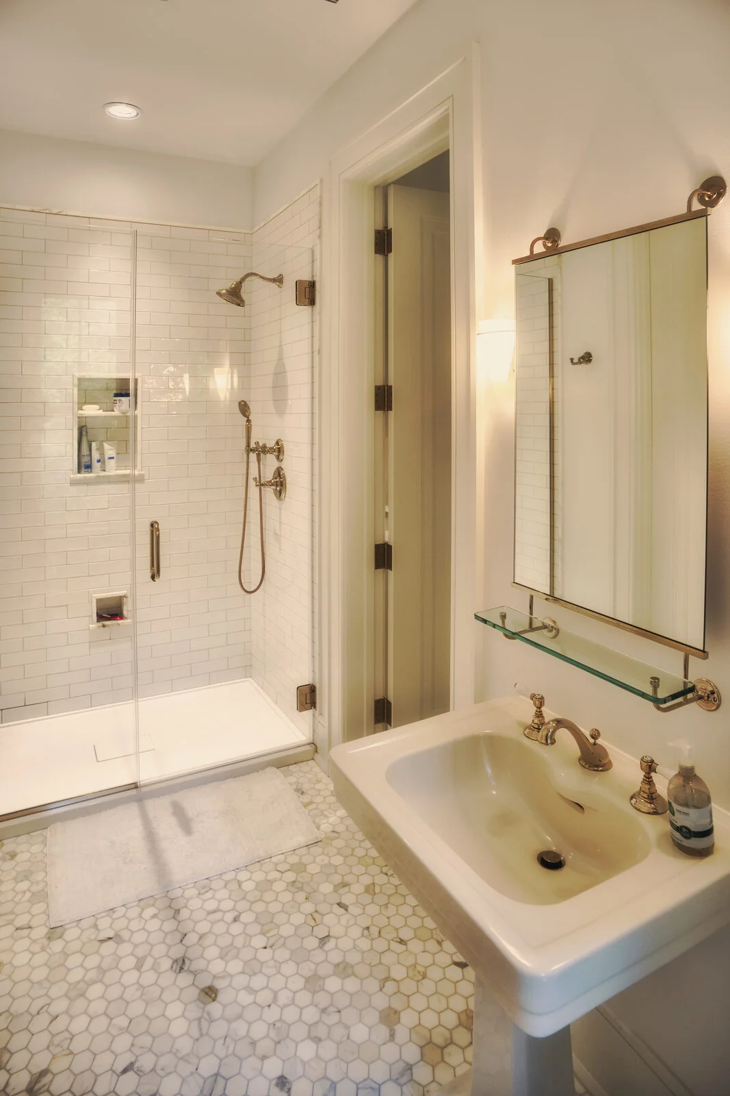 Guest bathroom with brass fixtures and marble hex tile